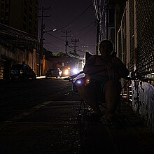 Fotografía de archivo del 29 de febrero de 2024 de una persona que camina en la oscuridad durante un corte eléctrico, en Maracaibo (Venezuela). 