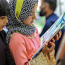 Children read a book as they visit a book exhibition in Kabul, Afghanistan, July 30, 2024