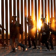 Fotografía de archivo de migrantes que caminan junto al muro en la frontera de EE.UU, y México en Lukeville, Arizona, EE.UU. 